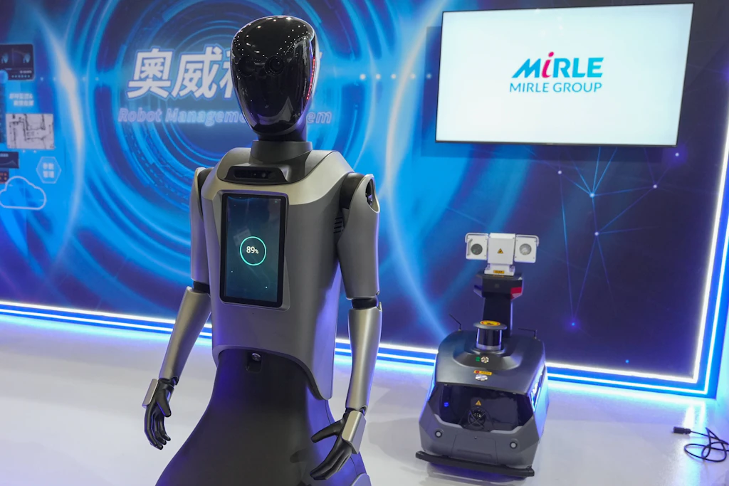 Ein humanoider und ein autonom fahrender Roboter des taiwanesischen Herstellers Mirle auf dem Messegelände.