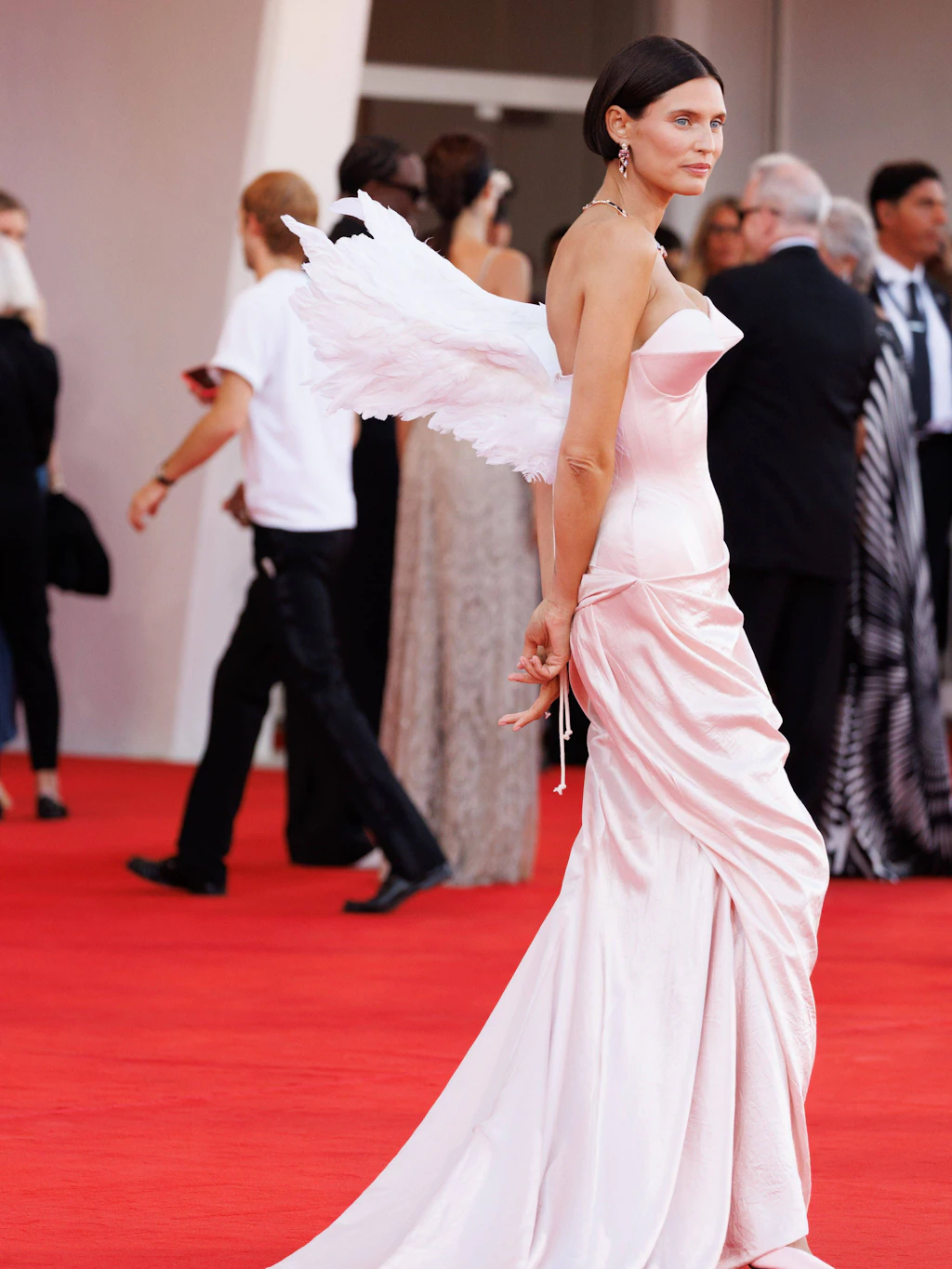 <strong>Flop:</strong> Engelchen oder Teufelchen? <strong>Bianca Balti</strong> entscheidet sich auf dem roten Teppich offenbar für beides – und schießt dabei ein kleines bisschen übers Ziel hinaus. In puderrosa Satin von Ilya Migmoon inklusive dramatischer Schleppe, setzt das italienische Model auf großen Märchen-Glamour. Das Korsettoberteil mit spitzen Cups und skulptural geformter Hüfte liefert zwar einen spannenden Kontrast zu ihrer eleganten Ausstrahlung. Doch die rosa Engelsflügel auf dem Rücken machen aus dem Look endgültig eine sehr wörtliche Interpretation von „himmlisch“.