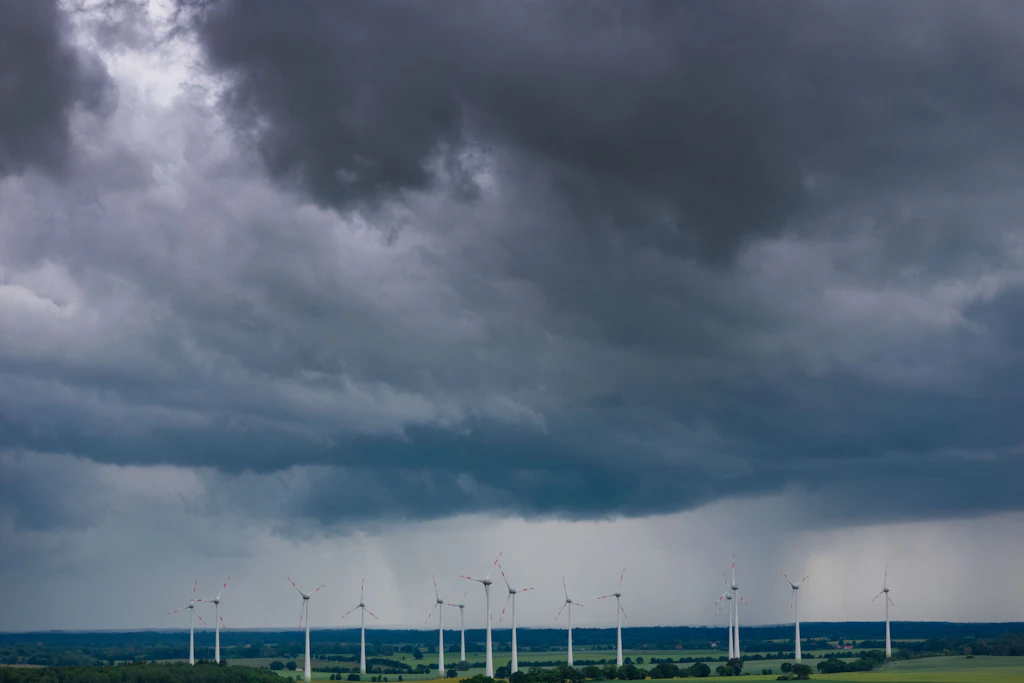 Dunkle Gewitterwolken ziehen über einen Windpark. Der Deutsche Wetterdienst warnt vor Hagel, Sturm und Starkregen.