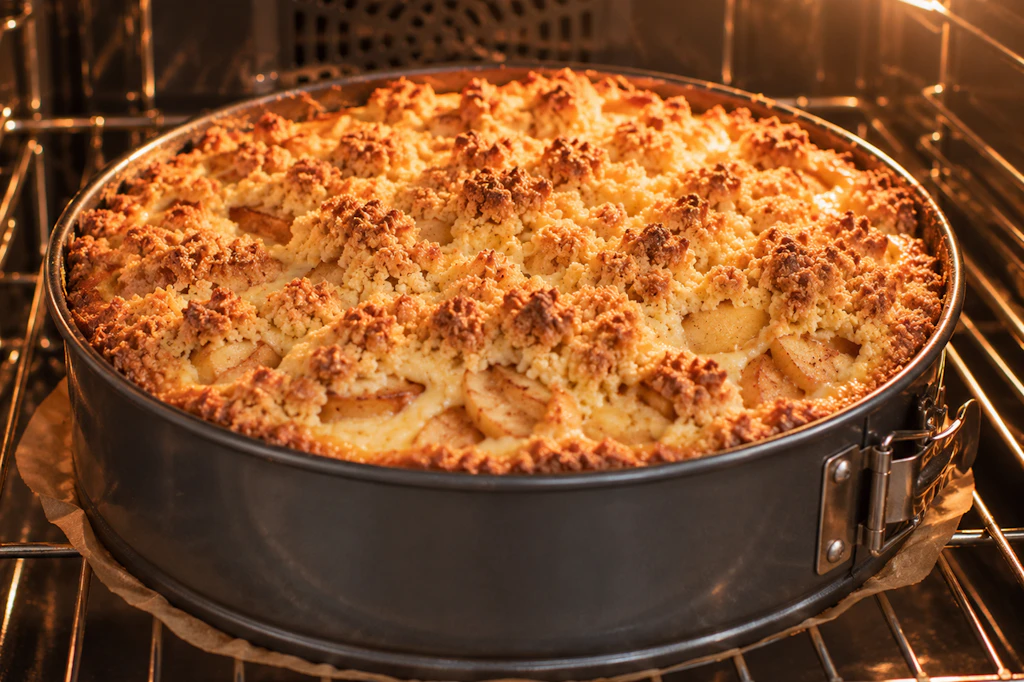 Der Apfelkuchen muss im Ofen backen, bis die Streusel obenauf richtig knusprig und goldbraun sind. Dann ist er fertig und kann warm oder kalt genossen werden.