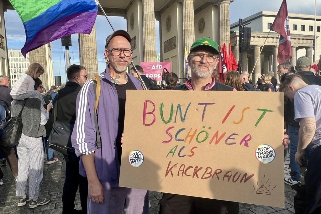 Heiko M. (mit Plakat) mit seinem Ehemann auf der Anti-AfD-Kundgebung vor dem Brandenburger Tor.