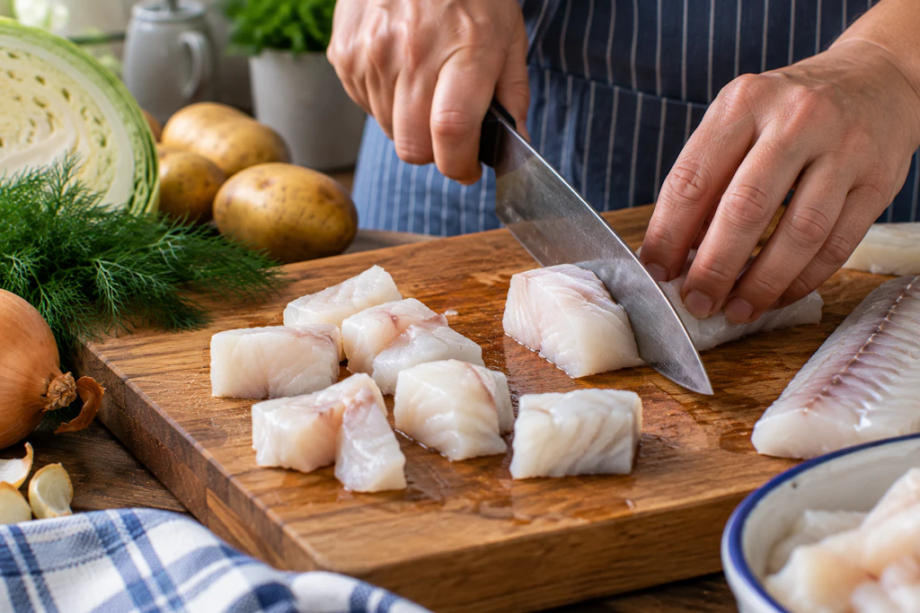 Für die Fischsuppe wird das Fischfilet in kleine Stücke geschnitten. Wer tiefgekühlten Fisch verwendet, braucht entsprechend ein scharfes Messer.