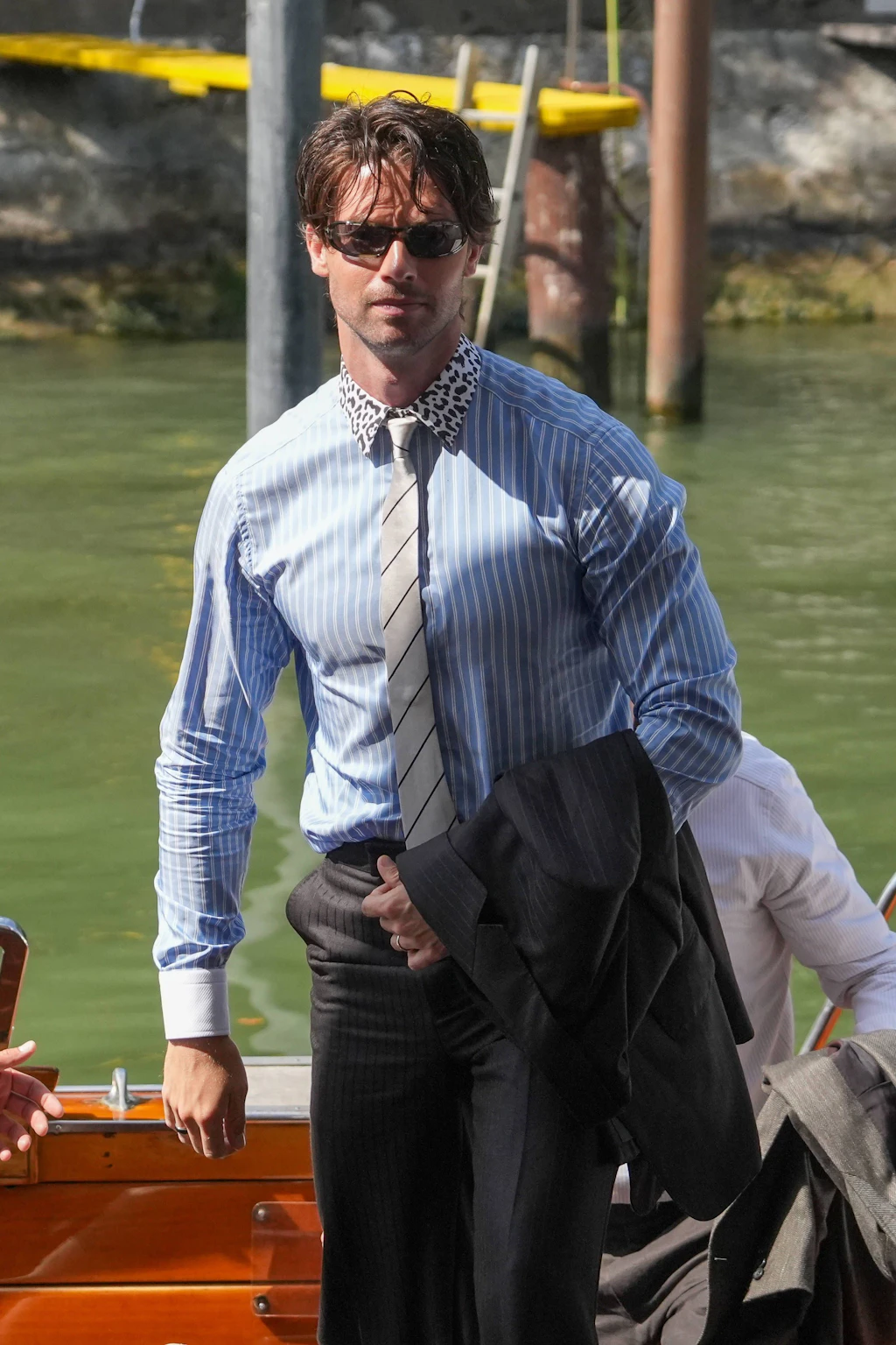 Flop: Patrick Schwarzenegger hat sich für seinen Auftritt zur Premiere von „Bunker“ offenbar gedacht: Wenn schon Muster, dann aber richtig. Das schwarze Sakko mit vertikaler Streifentextur, das blau-weiß gestreifte Hemd und die schräg gestreifte, silberfarbene Krawatte wären für sich genommen bereits eine mutige Entscheidung – der Leo-Print am Hemdkragen setzt dem Ganzen dann aber die Krone auf. Mutig, lückenlos durchgestreift und ein kleines bisschen zu viel auf einmal.