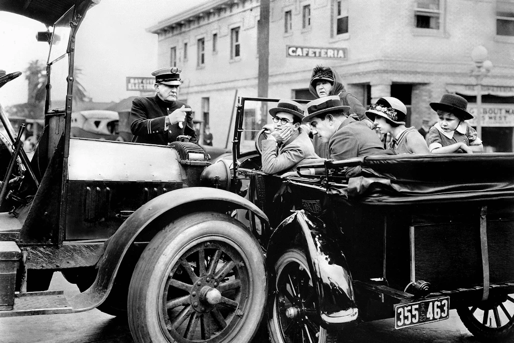 Wie im Film „Hot Water“ saßen Chauffeur und Passagiere in den ersten motorisierten Fahrzeugen weitgehend ungeschützt vor Wind und Wetter.