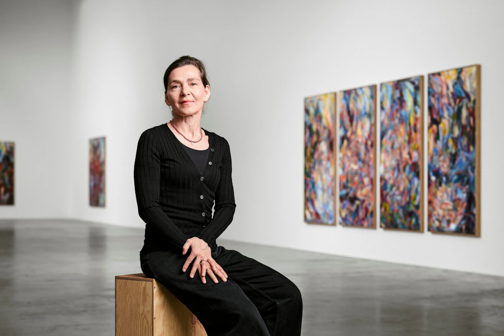 Sabine Moritz in der Galeriehalle vor „Fragment einer Idylle“ (vierteilig, ein „Quadriptychon“, 2026, Öl auf Leinwand)