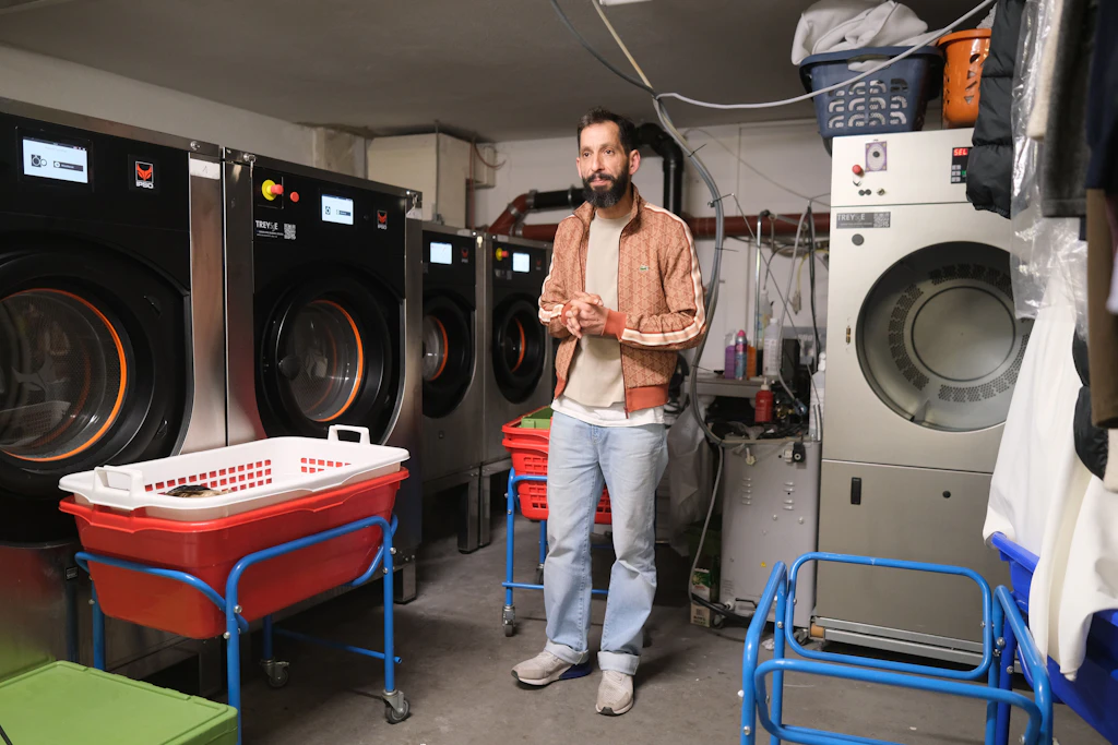 Bilal Ersoy, Chef der Wäscherei Bügelperle, neben seinen Maschinen.