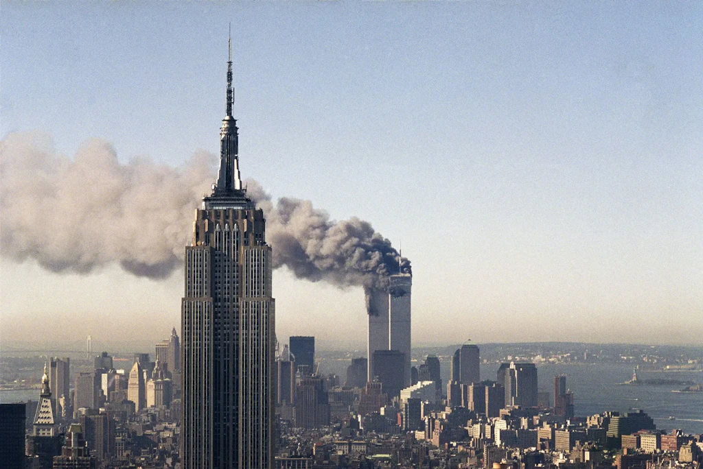 Die brennenden Zwillingstürme mit dem Empire State Building im Vordergrund