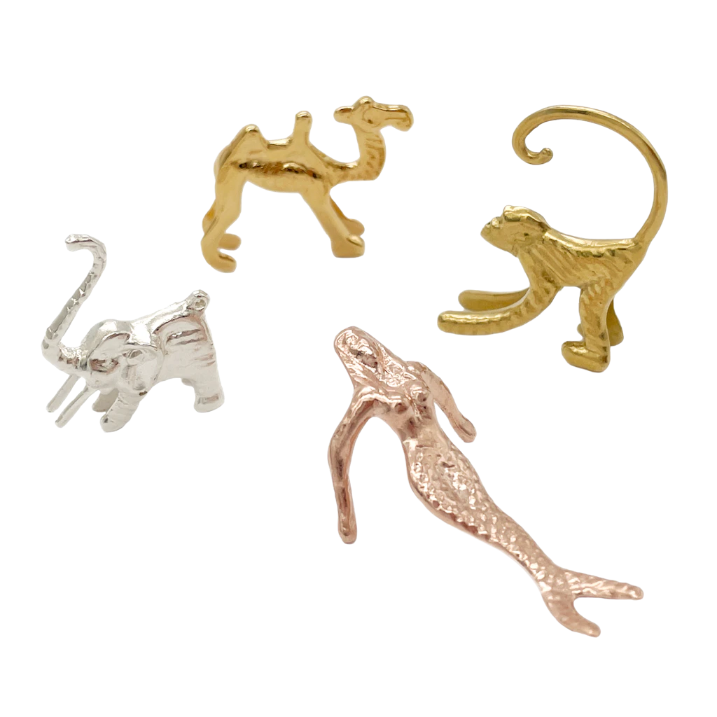 Glasmarkier-Set „Drink Markers“ bestehend aus Kamel, Affe, Meerjungfrau und Elefant, veredeltes Messing, Miglé, 195 Euro.