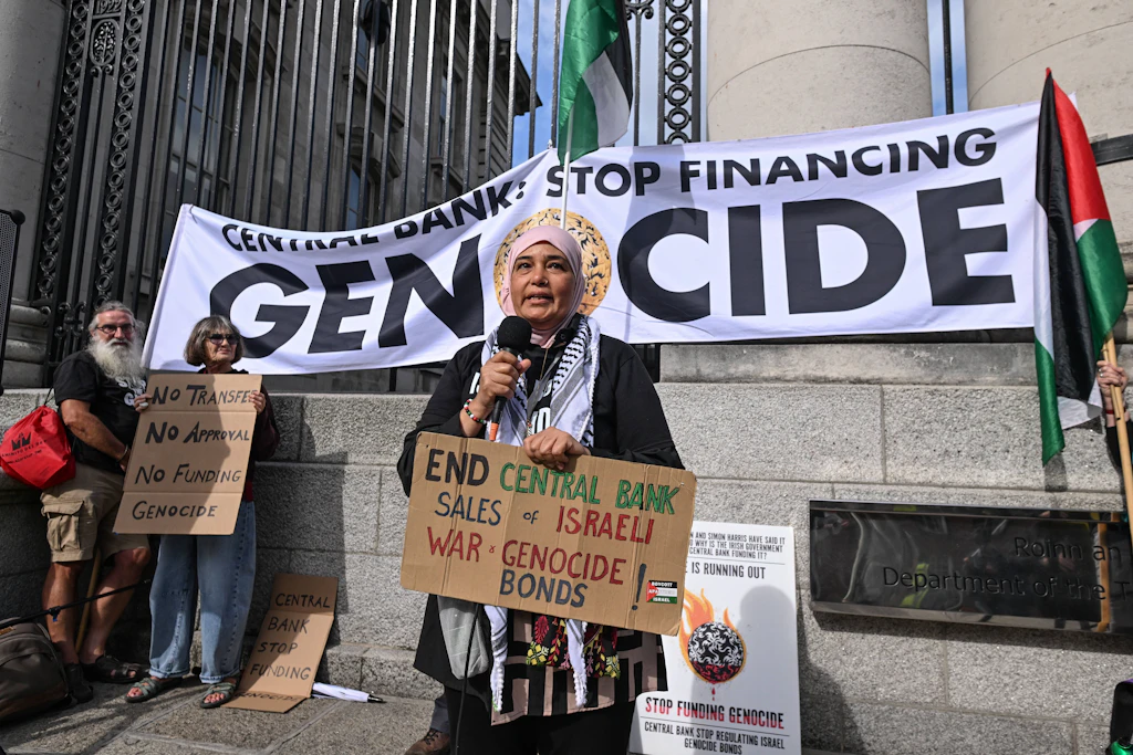 Eine Demonstrantin fordert am Vorabend von Donald Trumps Besuch in Dublin ein Ende des Verkaufs israelischer Kriegsanleihen durch die irische Zentralbank.