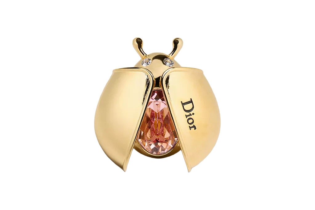 Brosche „Dior Lady Spark“ mit aufklappbaren Käferflügeln, Metall mit Goldfinish und rosafarbenem Kristall, Dior, 550 Euro.