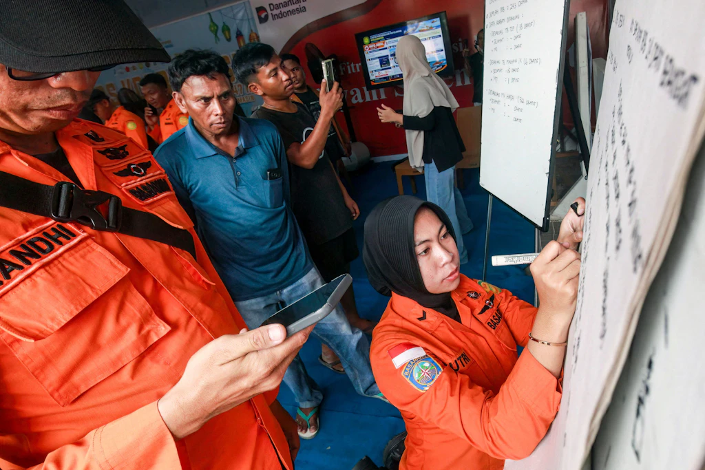 Angehörige verfolgen im Hafen von Banjarmasin die neuesten Angaben zur Rettungsaktion für die Passagiere der Virgo Transport 8.