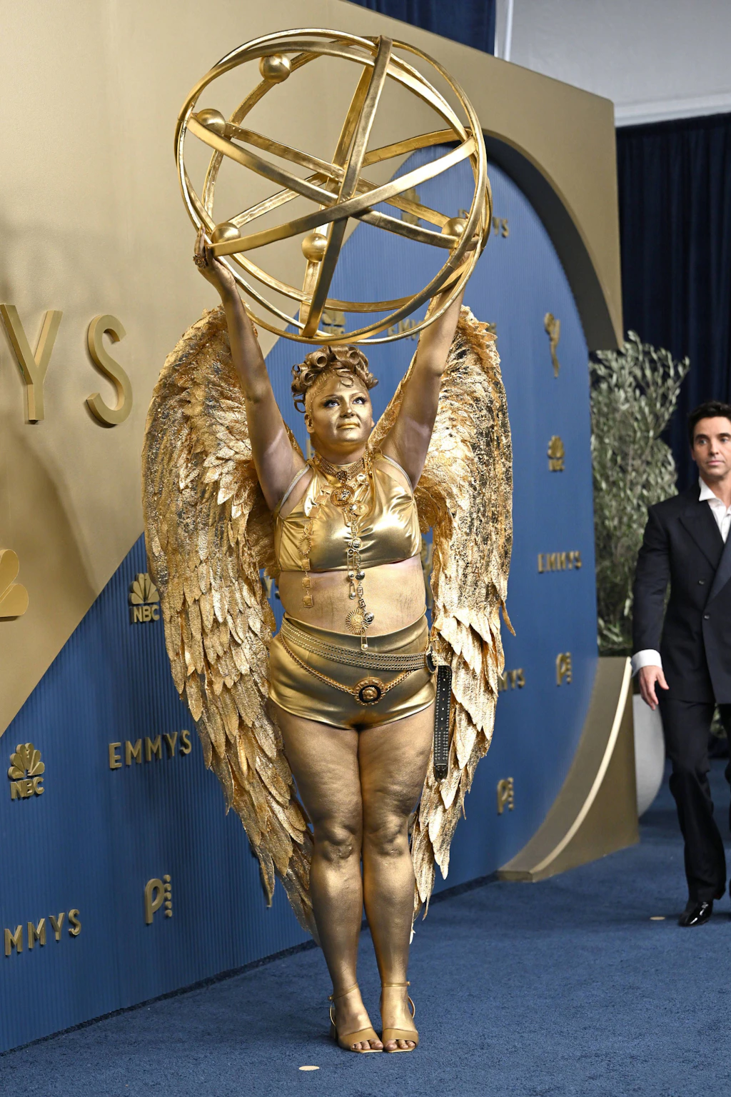 <strong>Flop:</strong> Es war ein goldener Auftritt – zumindest rein faktisch betrachtet. Die „Hacks“-Darstellerin Megan Stalter kam von Kopf bis Fuß in Gold, mit gewaltigen vergoldeten Flügeln, goldenem Crop-Top, Shorts und einer überdimensionierten Atomkugel über dem Kopf. Stalter erschien als das, was sie gern mit nach Hause genommen hätte – als Emmy-Statuette. Der Look ist natürlich mehr Witz als ernst gemeinte Mode. <br><br>Und genau dafür kann man Stalter Respekt zollen: Es gehört einiges dazu, sich an einem Abend voller tadellos gestylter Gäste selbst zur Witzfigur zu machen. Neu ist die Methode nicht – Stalter kam schon als Diet-Coke-Dose und als Kaffeebecher. Nominiert war sie erstmals als beste Nebendarstellerin in einer Comedyserie; gewonnen hat Kate O
