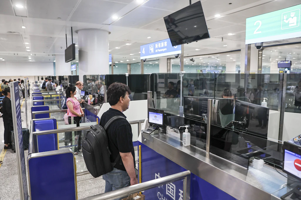 Passagiere passieren die Passkontrolle am internationalen Flughafen von Dalian im Nordosten Chinas.