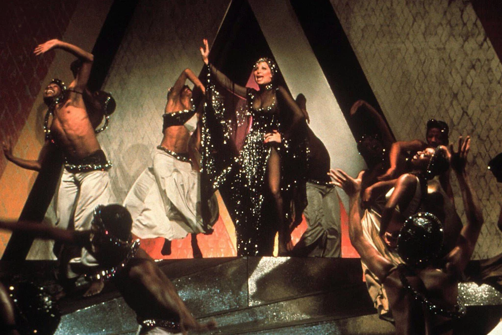 Barbra Streisand trägt in „Funny Lady“ ein schwarzes Bob Mackie-Kleid, mit Pailletten besetzt und mit Fledermausärmeln versehen.