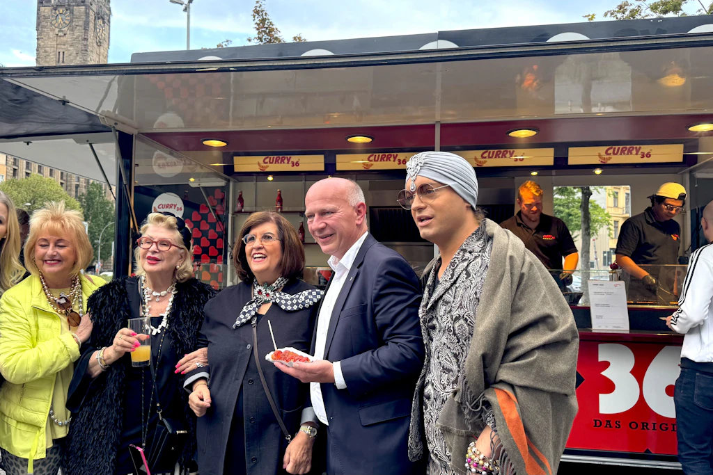 An der Curry36-Bude lächelt Judith Stückler (M.) mit Freunden der Partei, noch Bürgermeister Kai Wegner (2.v.rr) sowie Schauspieler Julian F.M. Stoeckel (r.) in die Kamera.