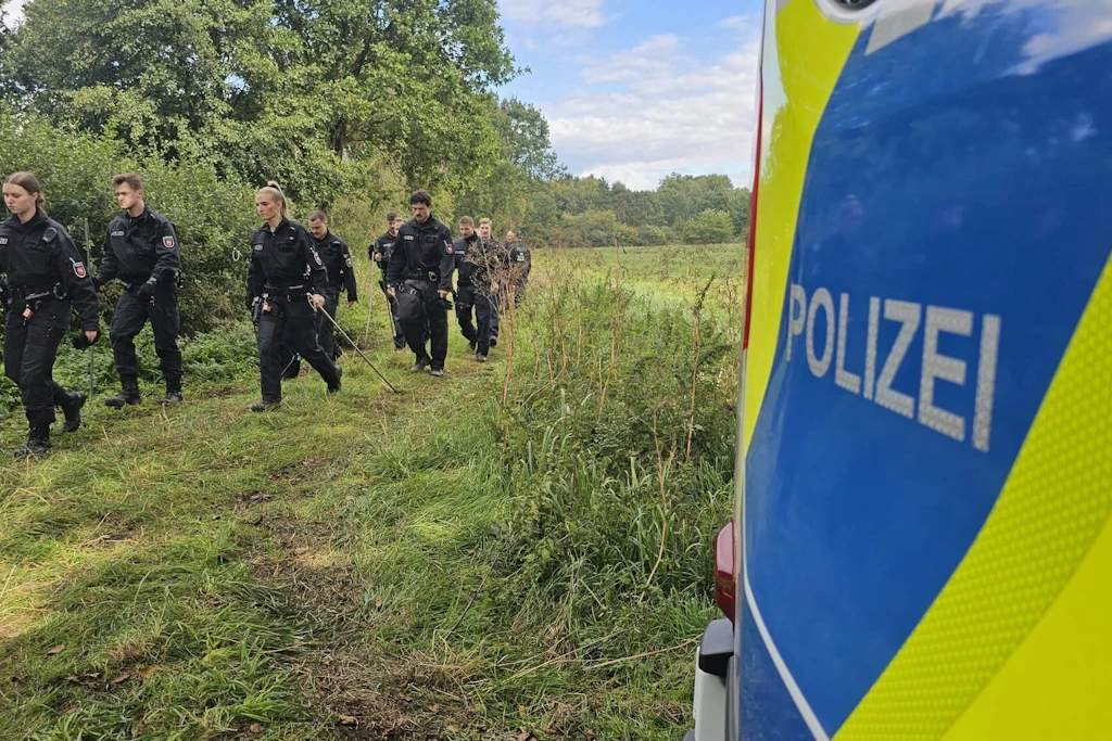 Polizisten suchen bei Wunstorf in der Region Hannover nach Drohnenteilen.