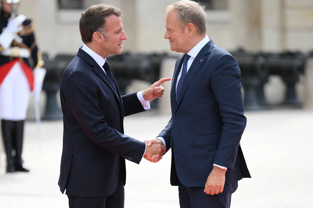 Frankreichs Präsident Emmanuel Macron begrüßt Polens Ministerpräsidenten Donald Tusk vor dem Gipfel der „Koalition der Willigen“ am 13. Juli 2026 im Hôtel des Invalides in Paris.