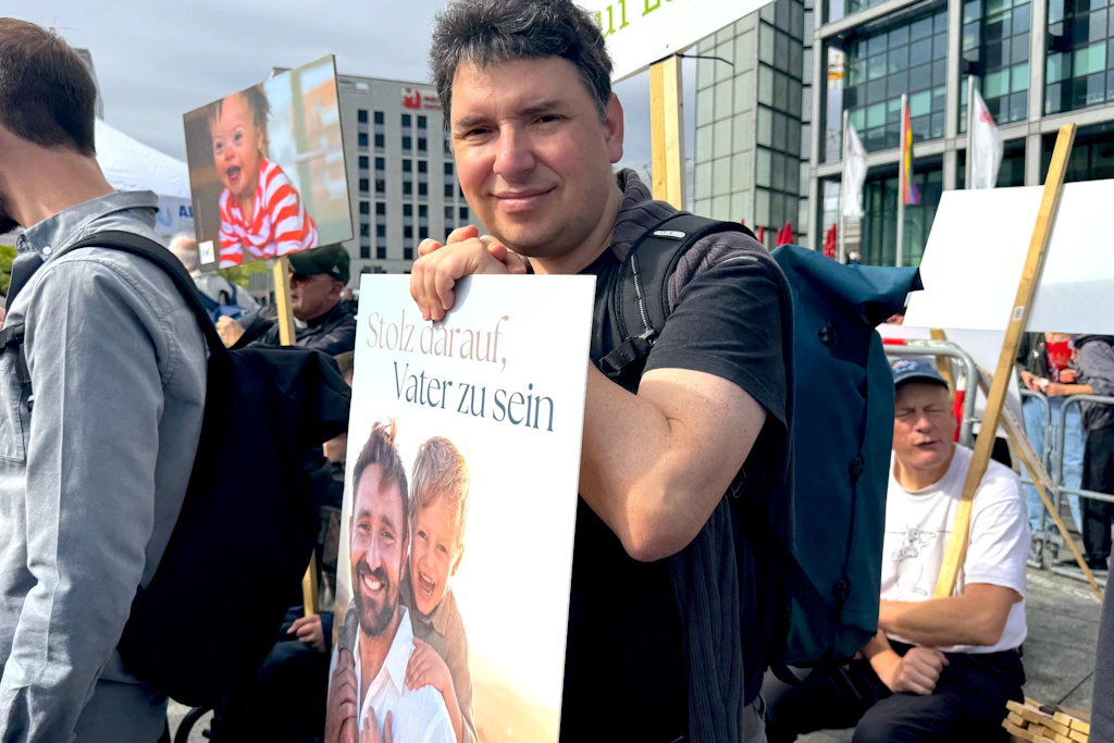Ein Mann mit dem Schild „Ich bin stolz darauf, Vater zu sein“.