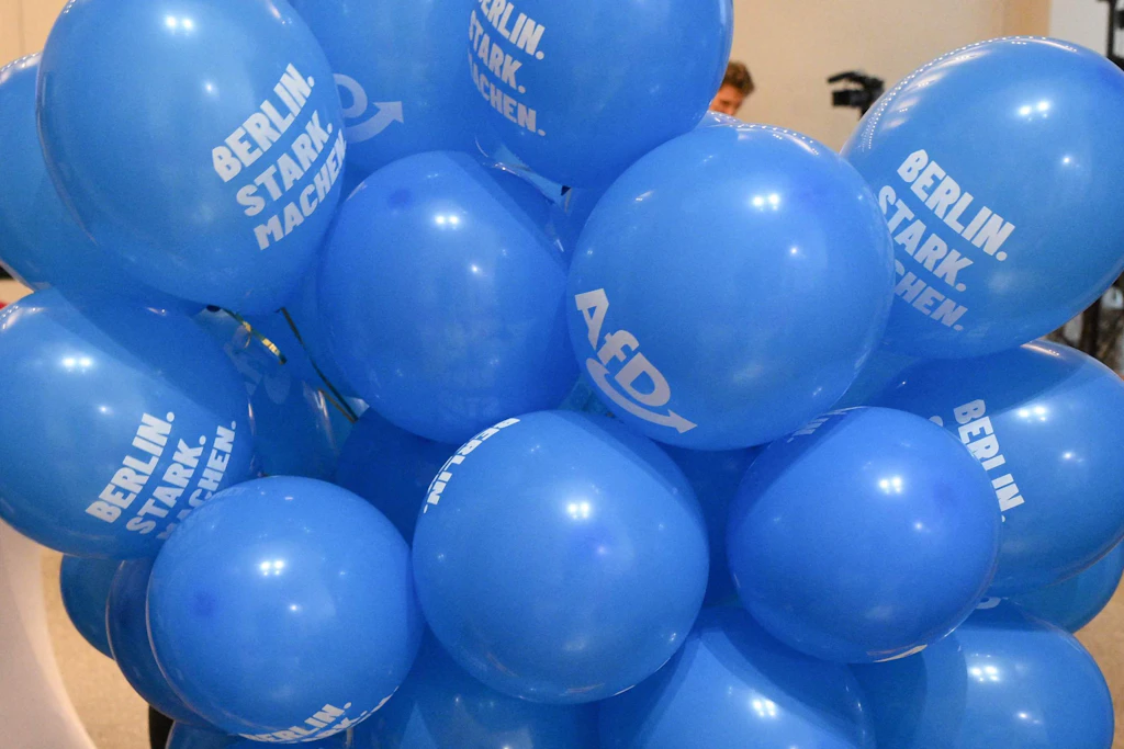 Ein AfD-Mitarbeiter trägt am Wahlabend blaue Luftballons zur Wahlparty der Partei im Berliner Abgeordnetenhaus.