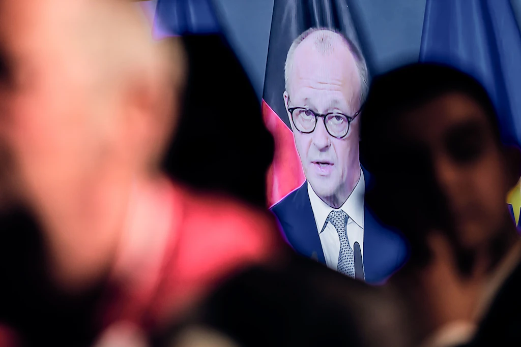 SPD-Anhänger verfolgen bei der SPD-Wahlparty die Ansprache von Bundeskanzler Friedrich Merz (CDU).