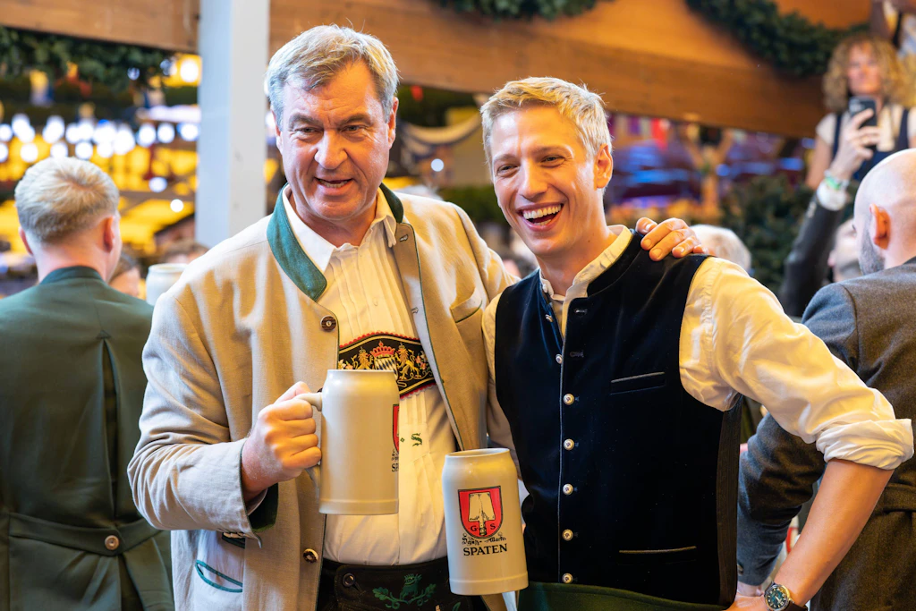 <strong>Top:</strong> Die Kombination des Grauens – oder doch des Glücks? Münchener Oberbürgermeister <strong>Dominik Krause</strong> hatte in diesem Jahr zum ersten Mal die Ehre, mit seinem Anstich im Festzelt Schottenhamel das Oktoberfest zu eröffnen. Nur zwei Schläge brauchte er – und bekam dafür von Bayerns Ministerpräsident <strong>Markus Söder</strong> ein anerkennendes Nicken. Ausgerechnet ihm, dem Grünen-Kritiker Söder, überreichte Krause traditionsgemäß die erste Maß des Festes.<br><br>Arm in Arm strahlten die beiden anschließend in die Kamera und lobten ihre gute Zusammenarbeit in Sachen Olympia. Modisch gingen sie jedenfalls eigene Wege: Krause entschied sich für eine eher jugendliche Tracht mit hellbrauner Lederhose und dunkelblauer Samtweste, während Söder in seiner dunklen Lederhose und Hosenträgern mit gesticktem Bayern-Wappen den Ur-Bayer mimte.