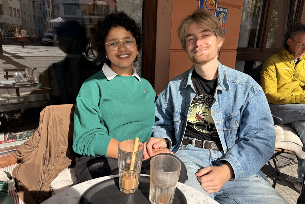 Nadine Sakr und Enno Virgens trinken am Doberaner Platz in Rostock einen Kaffee in der Sonne.