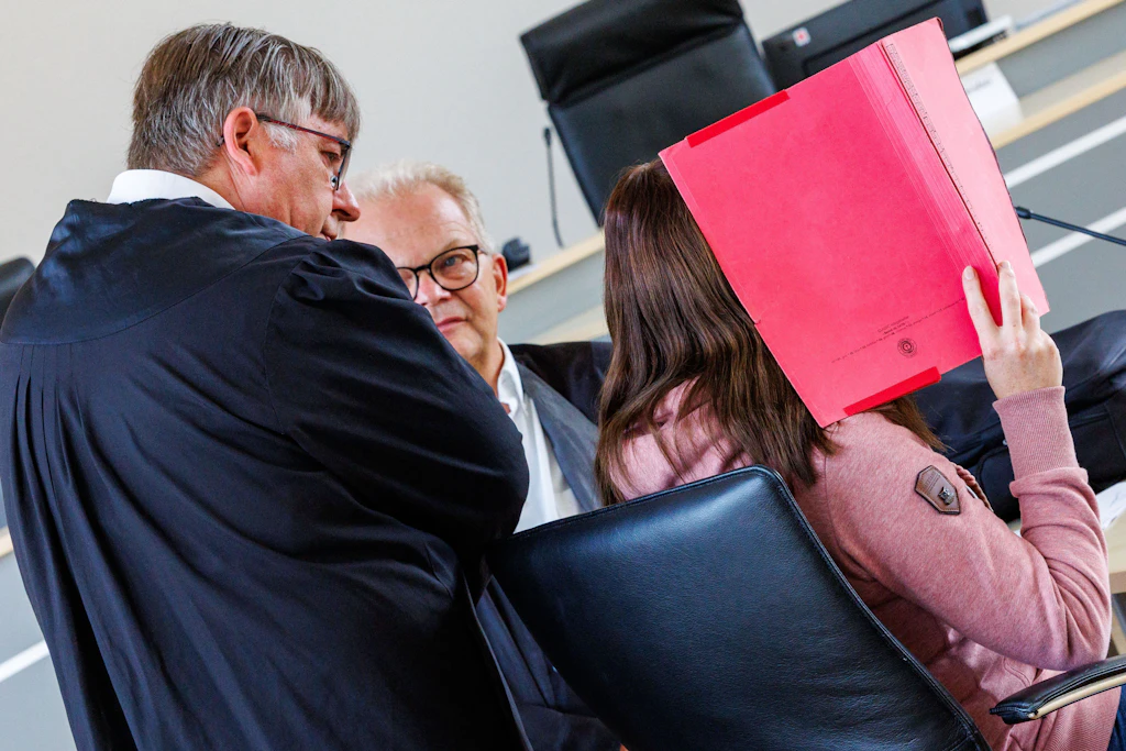 Die Angeklagte spricht mit ihren Anwälten Andreas Ohm (l.) und Thomas Löcker im Landgericht Rostock am 23. September.