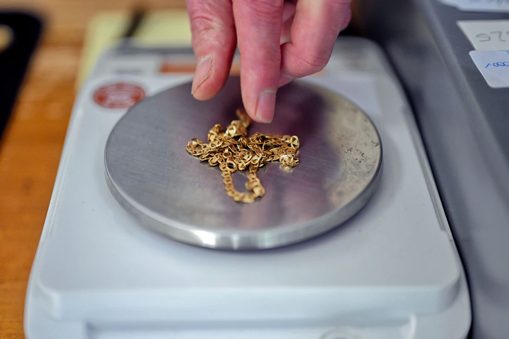 Eine Goldkette auf der Feinwaage eines Ankaufsgeschäfts: Was Schmuck bringt, hängt vom Feingehalt und vom Tageskurs ab. (Symbolbild)