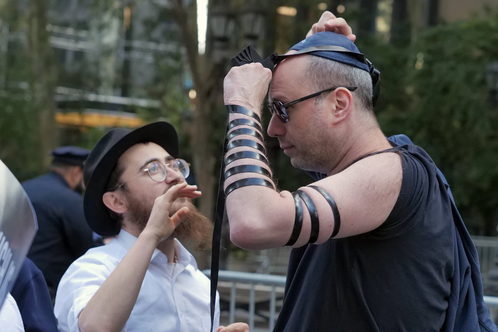 New York, 23. September 2026: Ein Mann legt Tefillin an. Hunderte demonstrieren vor der UN gegen Antisemitismus – unter dem Motto „No More Excuses“.