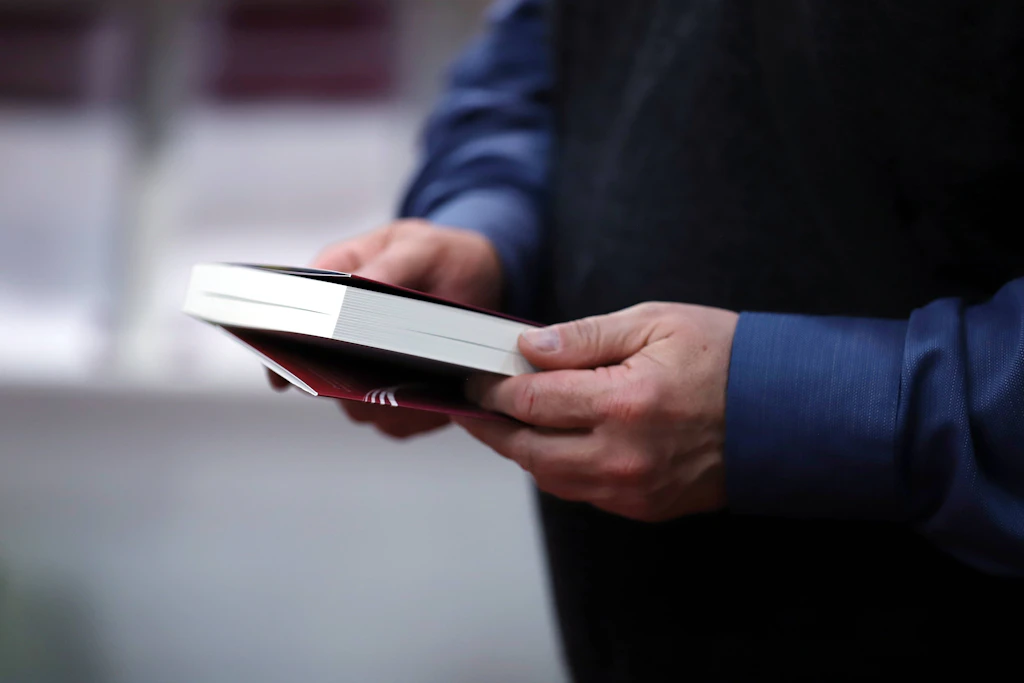 Ein Mann hält ein Buch in der Hand.