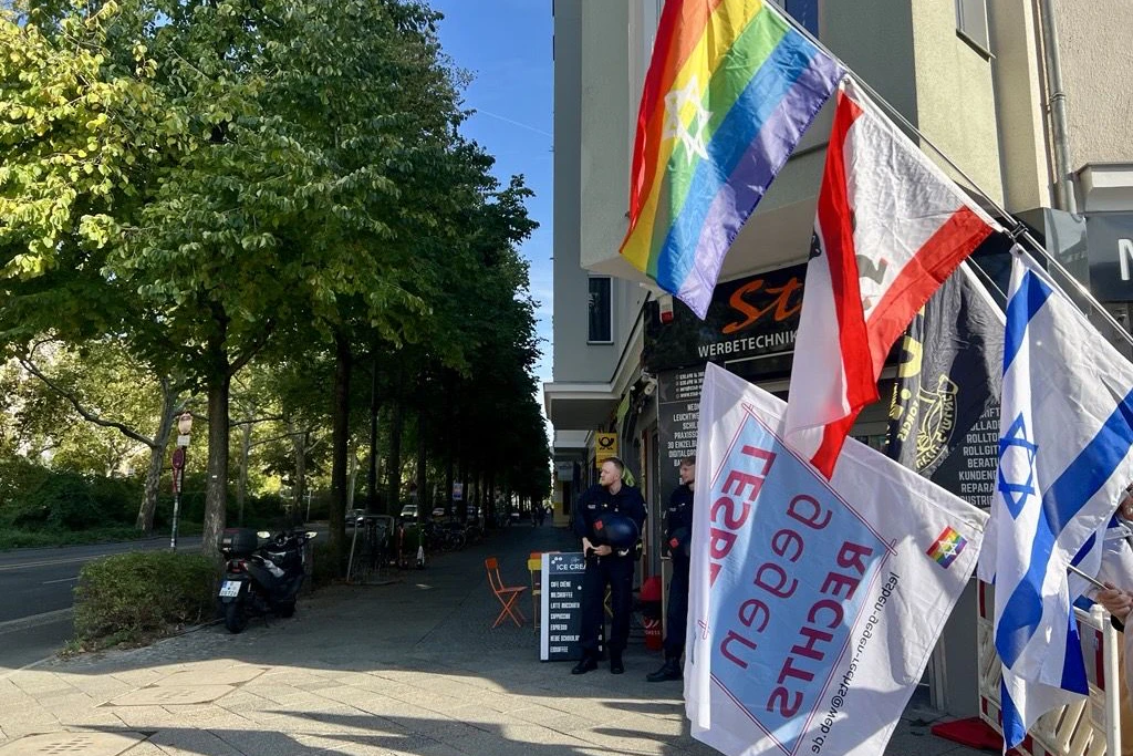 Kurz vor der Konfrontation ist es noch ruhig an der Baerwaldstraße: Flaggen der Demonstration für Israel werden über die Absperrung gehalten.
