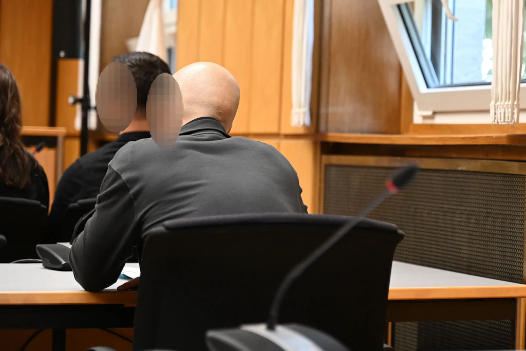 Die beiden Angeklagten sitzen in einem Saal des Landgerichts Heilbronn. Sie sollen ihren Ex-Chef gefesselt, im Kofferraum entführt und ausgeraubt haben.