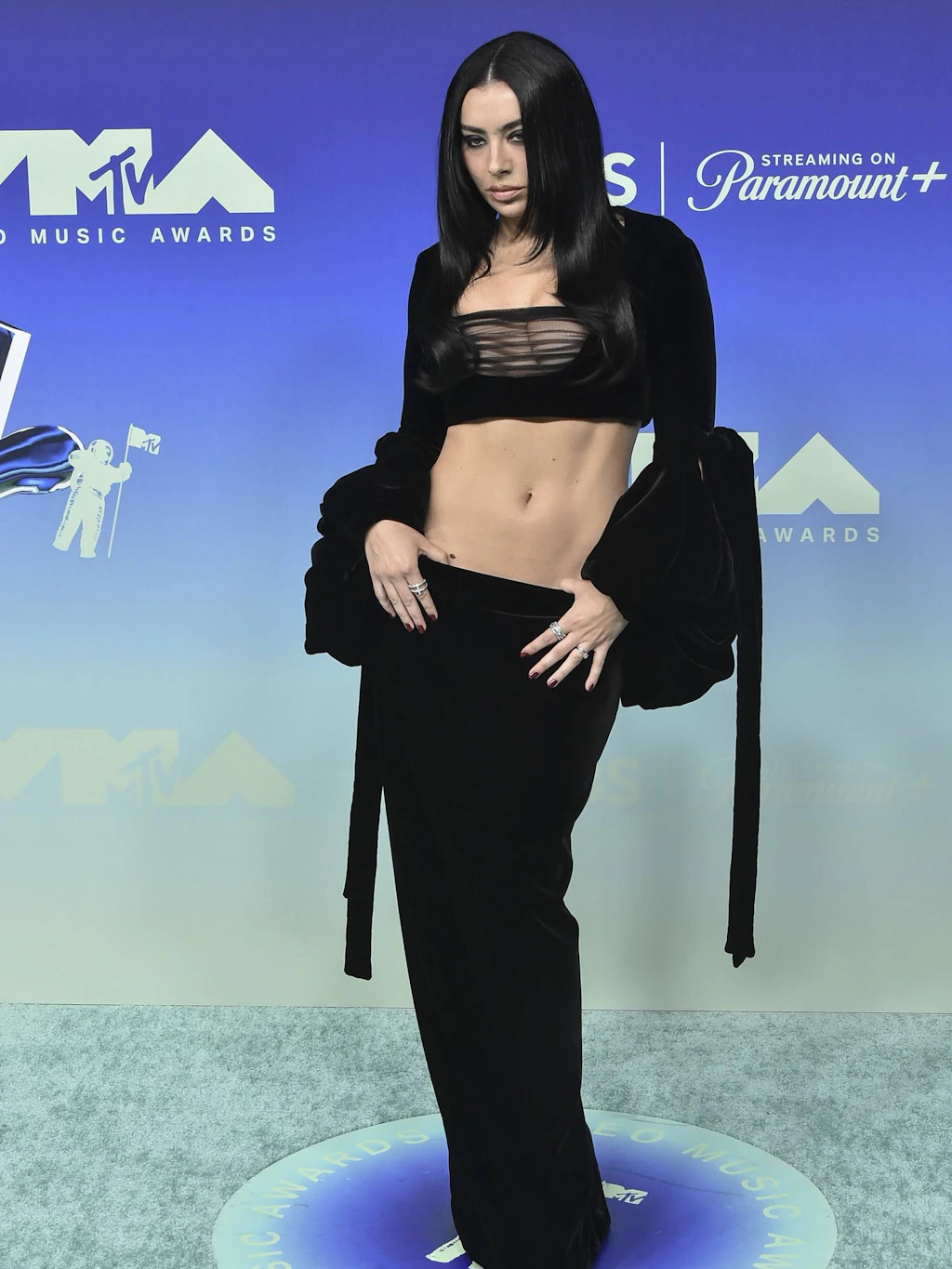 <strong>Top:</strong> Charli xcx gehörte zweifelsohne zu den bestgekleideten Personen des Abends. Die Sängerin erschien in einem maßgeschneiderten, tiefschwarzen Zweiteiler von Saint Laurent. Mit dem bauchfreien Look perfektionierte sie den „Goth-Glam“. Das Crop-Top und der bodenlange Rock formten eine skulpturale Silhouette, während extralange, fließende Ärmel dem Auftritt eine avantgardistische Dramatik verliehen. Ein klug reduziertes Beauty-Styling mit glattem Haar und der bewusste Verzicht auf opulenten Schmuck unterstrichen die klare, selbstbewusste Attitüde. Mit dieser kompromisslosen Inszenierung kreierte die Sängerin einen der stärksten Mode-Momente des gesamten Abends.