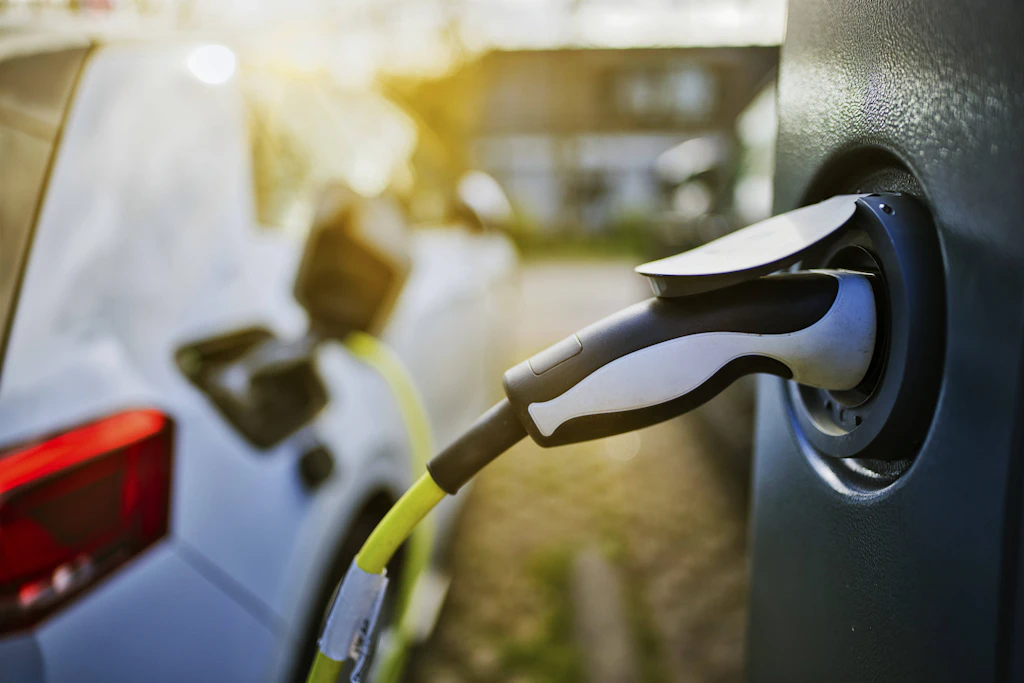 Ein E-Auto ist per Ladekabel an eine Ladesäule angeschlossen. Künftig kann der Strom aus dem Fahrzeug zurück ins Netz fließen.