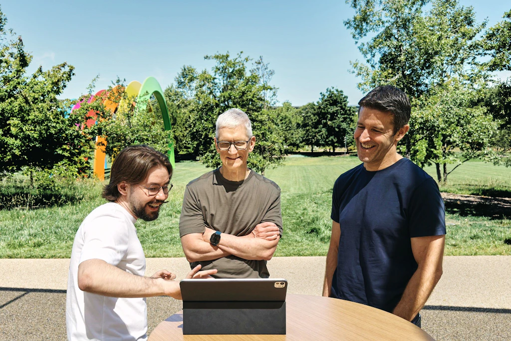 Anton Baranov präsentiert bei der diesjährigen Swift Student Challenge von Apple, seine Erfindung vor  dem damaligen CEO Tim Cook (links) und dem jetzt amtierenden Apple-Chef John Ternus (rechts).