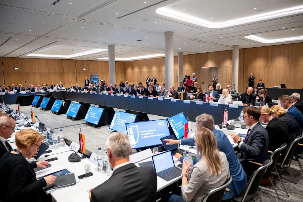 Teilnehmer der Innenministerkonferenz (IMK) 2026 sitzen im Saal zusammen.