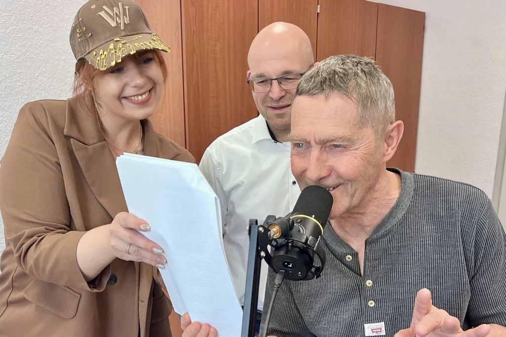 Landrat Christian Müller (M.) und Gina Werthe, Projektkoordinatorin und Sachbearbeiterin Social Media des Landkreises Prignitz, hören Udo Schenk bei der Aufnahme der Ansagen zu.