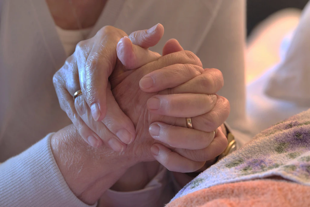 Eine ambulante Pflegekraft hält die Hand einer Patientin: Schwarze Schafe bringen die gesamte Branche in Verruf (Archivbild).