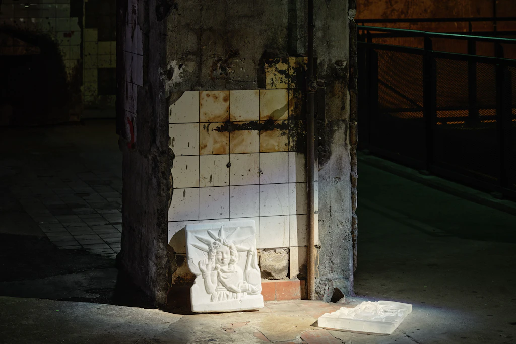 Artefakte des persischen Sonnenkults aus dem Metropolitan Museum an einer Säule der Berghain-Kesselhalle