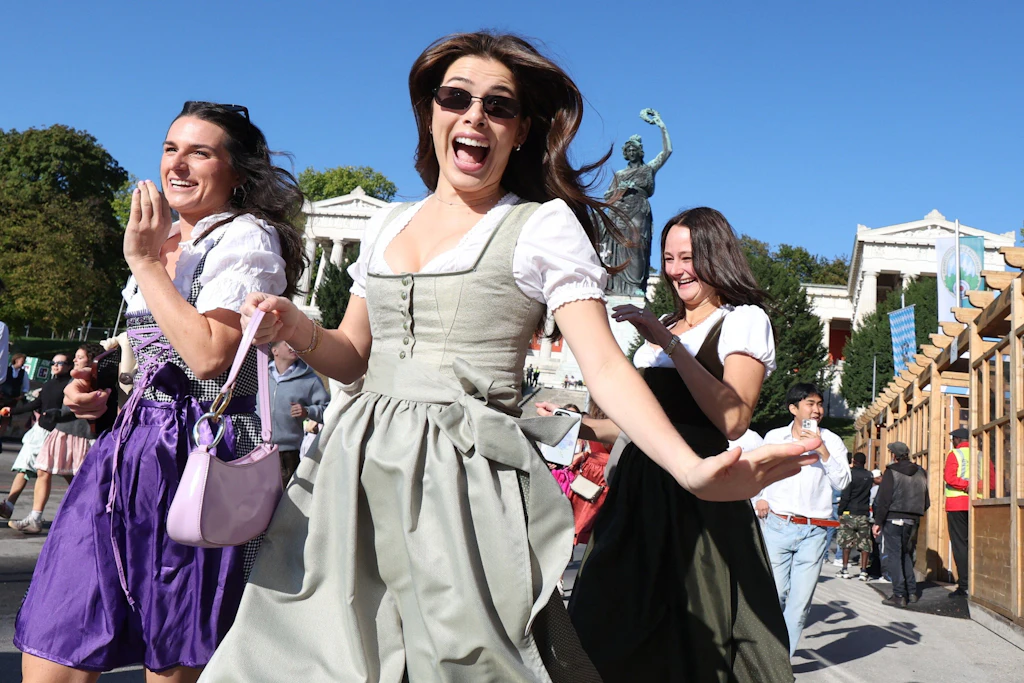 Die ersten Besucherinnen rennen zum Start des Oktoberfestes nach dem Einlass auf die Festwiese zu den Zelten.