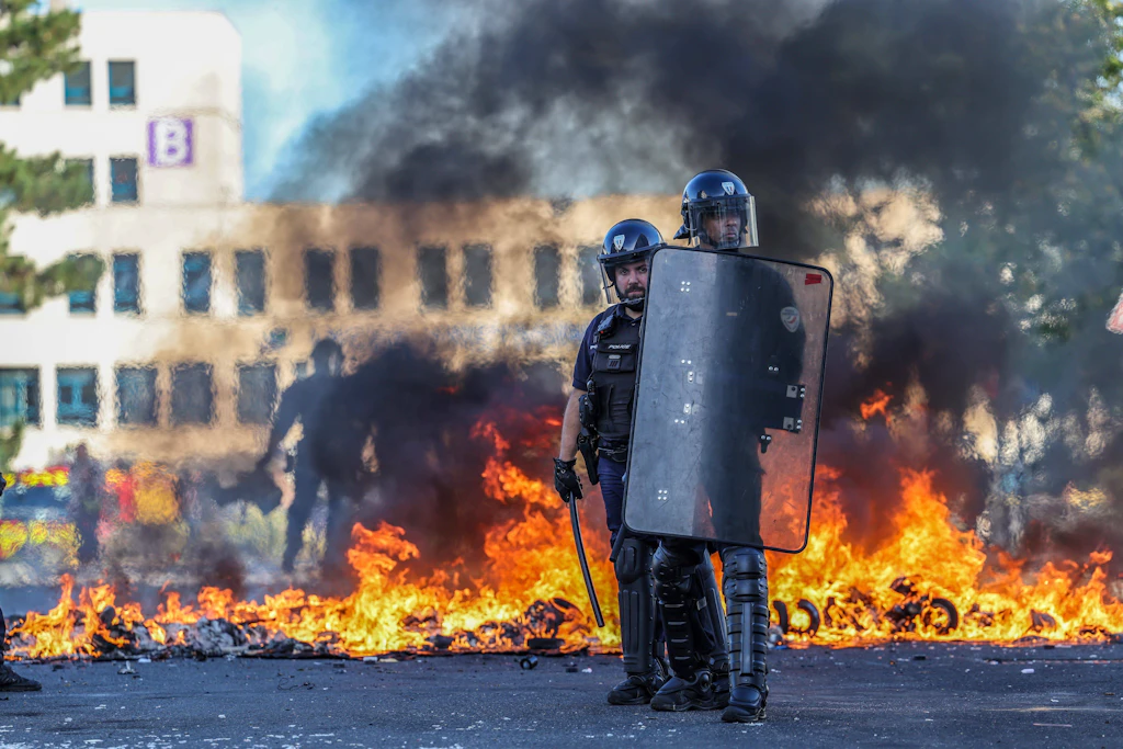 Polizisten stehen nahe einem Feuer vor dem Lycée Freyssinet in Saint-Brieuc. Jugendliche haben dort im Zuge der landesweiten Schulproteste demonstriert.