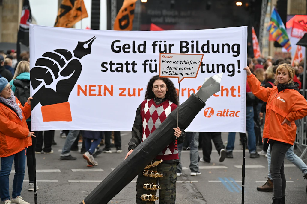 Eine Teilnehmerin demonstriert mit einem überdimensionalen Füllfederhalter für Bildung.