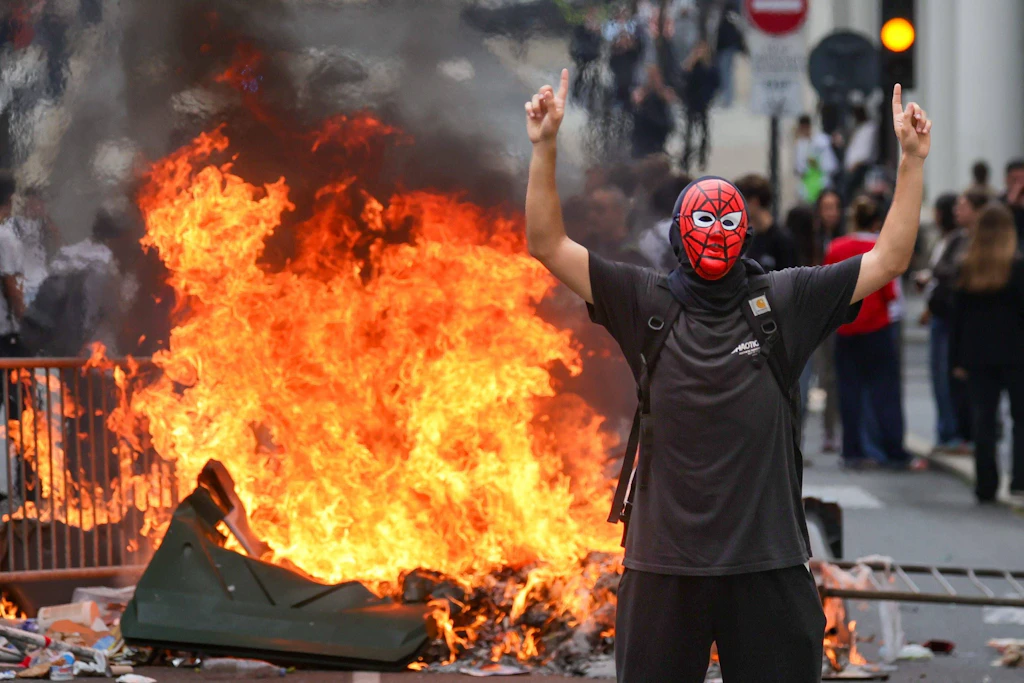 Ein Maskierter vor einer brennenden Barrikade im südwestfranzösischen Pau. Dort protestierten Schüler.