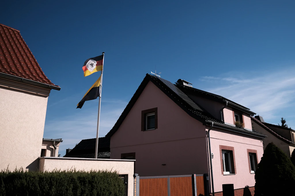 Ein Wohnhaus in Holzdorf mit Deutschland- und Sachsen-Anhalt-Fahne. Der Ort liegt direkt an der Landesgrenze, der größte Teil des Fliegerhorsts auf der Brandenburger Seite.