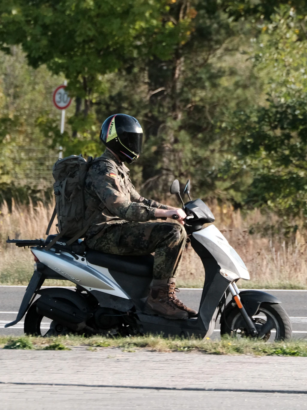 Ein Soldat fährt auf einem Motorroller durch Holzdorf. Der Fliegerhorst ist Standort des Raketenabwehrsystems Arrow 3.