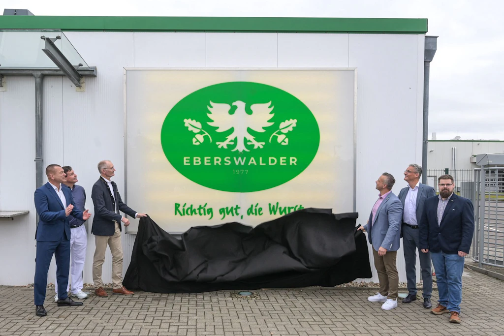 Axel Knau, Geschäftsführer Anhalter Fleischwaren, Gerd Buggisch, Werkleiter Anhalter Fleischwaren, Andreas Dittmann,               Bürgermeister Stadt Zerbst/Anhalt, Andy Grabner, Landrat des Landkreis Anhalt-Bitterfeld, Sebastian Kühn, Geschäftsführer EWN Eberswalder und Simon Büdgenbach,               Produktionsleiter Anhalter Fleischwaren (v.l.), enthüllen das Firmenlogo von Eberswalder am neuen Standort in Zerbst.