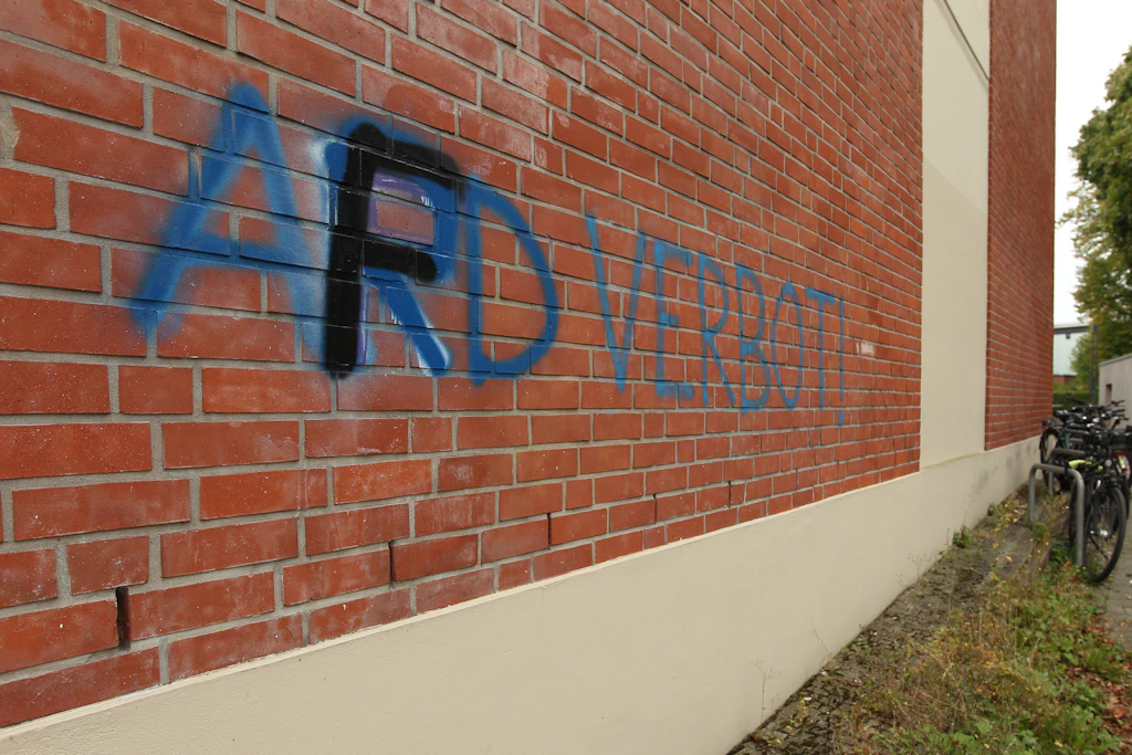 Ja, was denn nun? An die Fassade eines Gebäudes in Hamburg wurde der Schriftzug „AFD-Verbot“ gesprüht. Zwischenzeitlich wurde der Schriftzug von Unbekannten in „ARD-Verbot“ übersprüht, bevor er nun erneut in „AFD-Verbot“ übersprüht wurde.