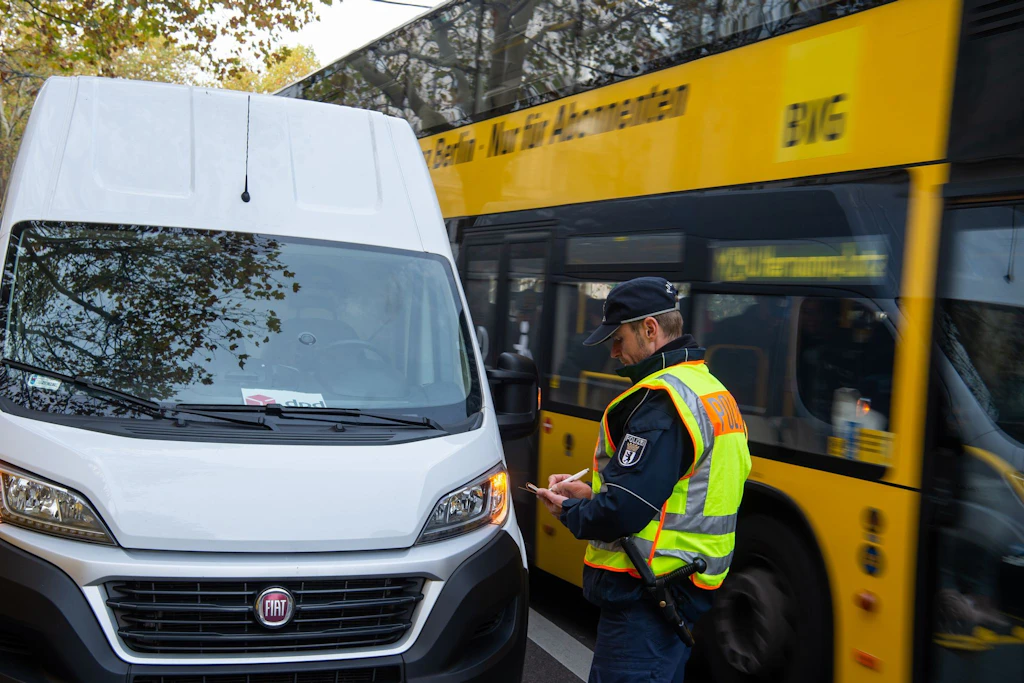 Ein Polizist vor einem Lieferwagen, der in der zweiten Reihe hält.