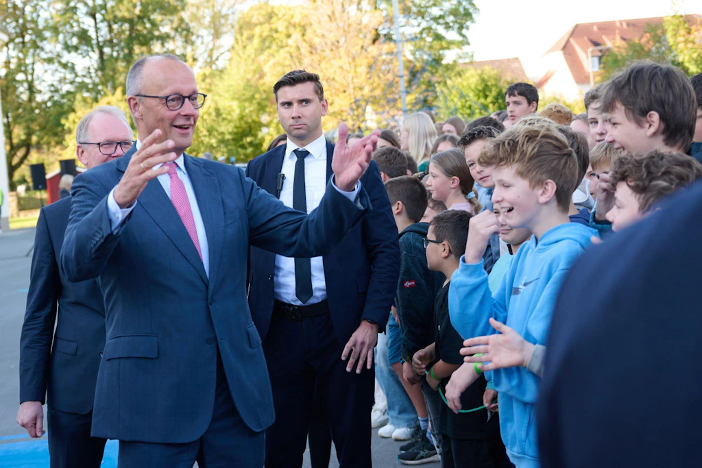 Bundeskanzler Friedrich Merz (CDU) spricht beim Besuch seines ehemaligen Gymnasiums, dem Friedrich-Spee-Gymnasium, mit Schülern.