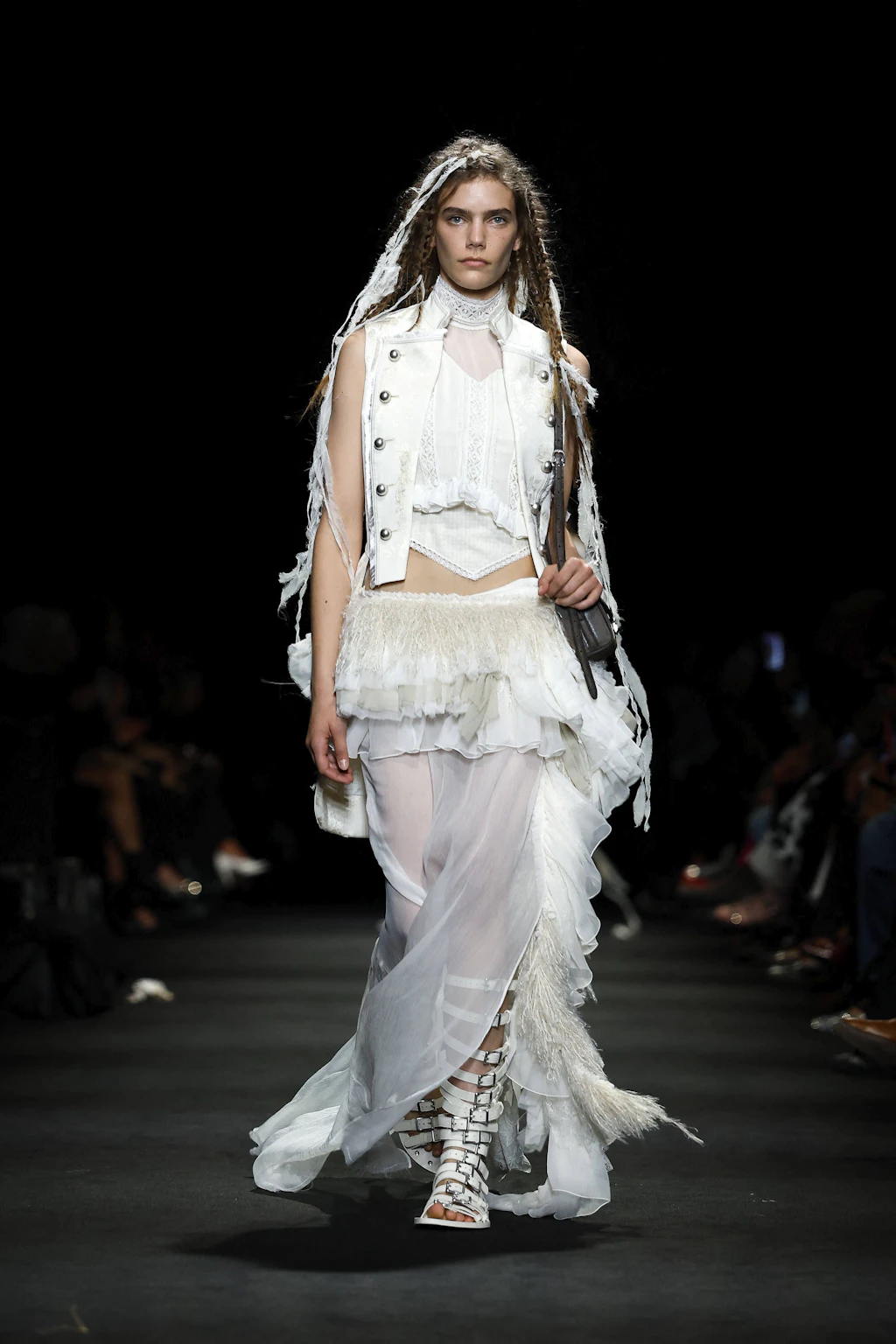 „Lonesome Heaven“, so lautet der Titel der Kollektion, mit der der Designer Stefano Gallici auf der Paris Fashion Week erneut unter Beweis stellt, dass er ein feines Gespür für das Erbe von Ann Demeulemeester hat, die sich seit 2013 komplett aus ihrem Modehaus zurückgezogen hat. Dekonstruierte Military-Westen treffen auf fließende, transparente Stoffbahnen, während asymmetrische Rüschenröcke dem typisch androgynen Gothic-Chic eine fast elfenhafte Leichtigkeit verleihen. Ein meisterhaftes Spiel mit Texturen in reinem Weiß und tiefem Schwarz, das die Seele der Marke perfekt einfängt und zeitgemäß auflädt.